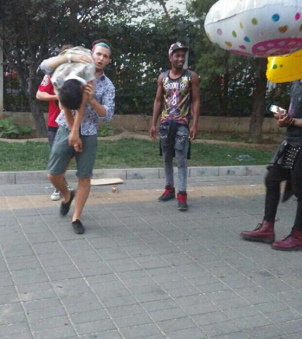 外籍男子当街脚踏肩扛醉汉拍照